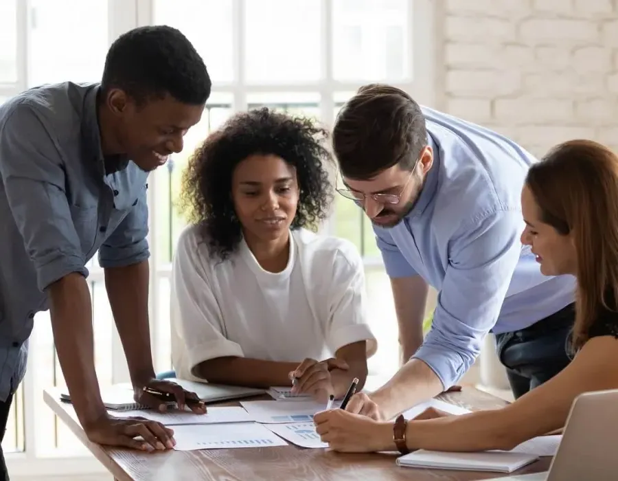 Three HR managers reviewing documents in team meeting